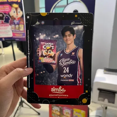 Guest holding a printed AI photobooth result with custom event branding and campaign design