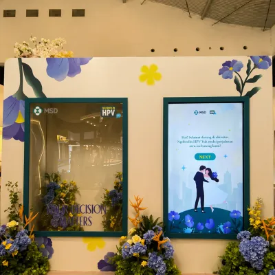 MSD HPV interactive journey event booth with digital educational screen, branded floral installation, and immersive activation setup for health awareness campaign