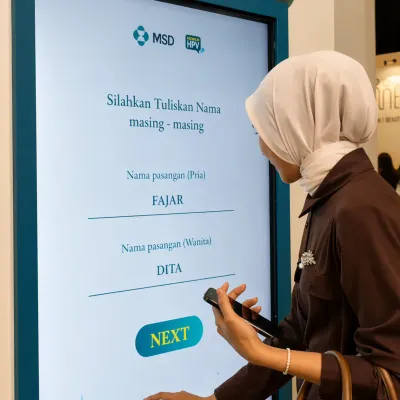 Participant using a touchscreen web app inside the MSD HPV interactive journey booth during an educational event activation experience