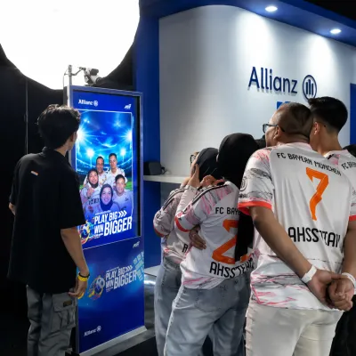 Participants viewing their Allianz football-themed photobooth result on the event LED display system