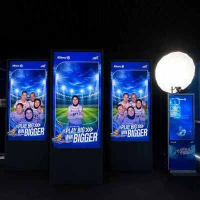 Wide event view of Allianz real-time LED photobooth installation with three large display panels and digital signage booth